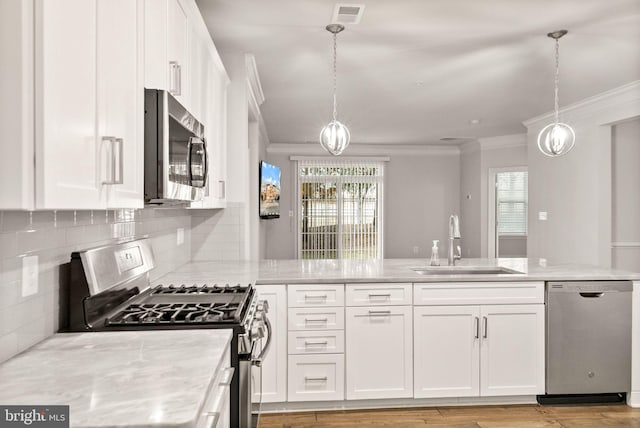 kitchen with appliances with stainless steel finishes, sink, pendant lighting, and white cabinets