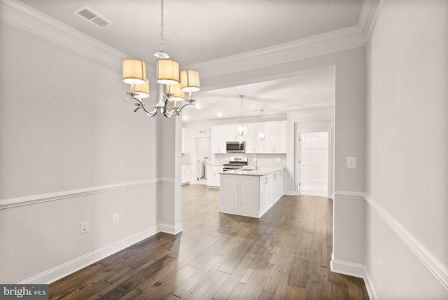 kitchen with sink, white cabinetry, ornamental molding, appliances with stainless steel finishes, and pendant lighting