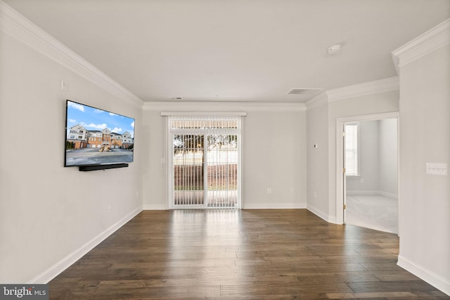 spare room with ornamental molding, a healthy amount of sunlight, and dark hardwood / wood-style floors