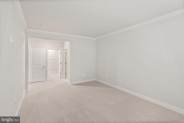 empty room with ornamental molding and light colored carpet