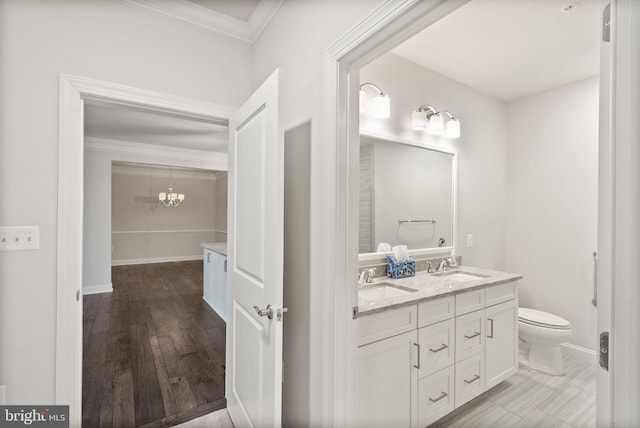 bathroom featuring vanity, a notable chandelier, crown molding, and toilet