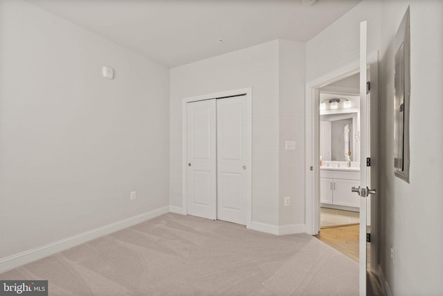 unfurnished bedroom featuring light carpet and a closet