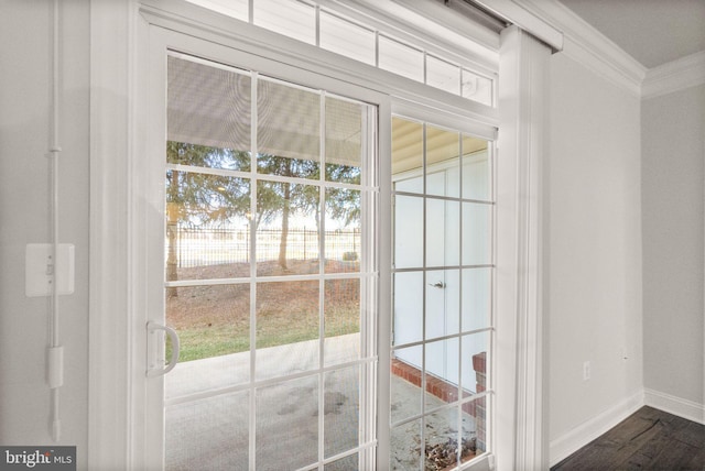 entryway with dark hardwood / wood-style flooring, ornamental molding, and a healthy amount of sunlight