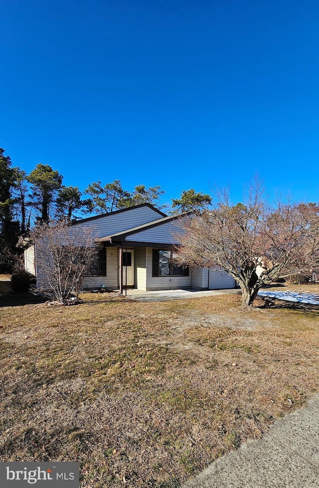 view of front facade with a front lawn and a patio