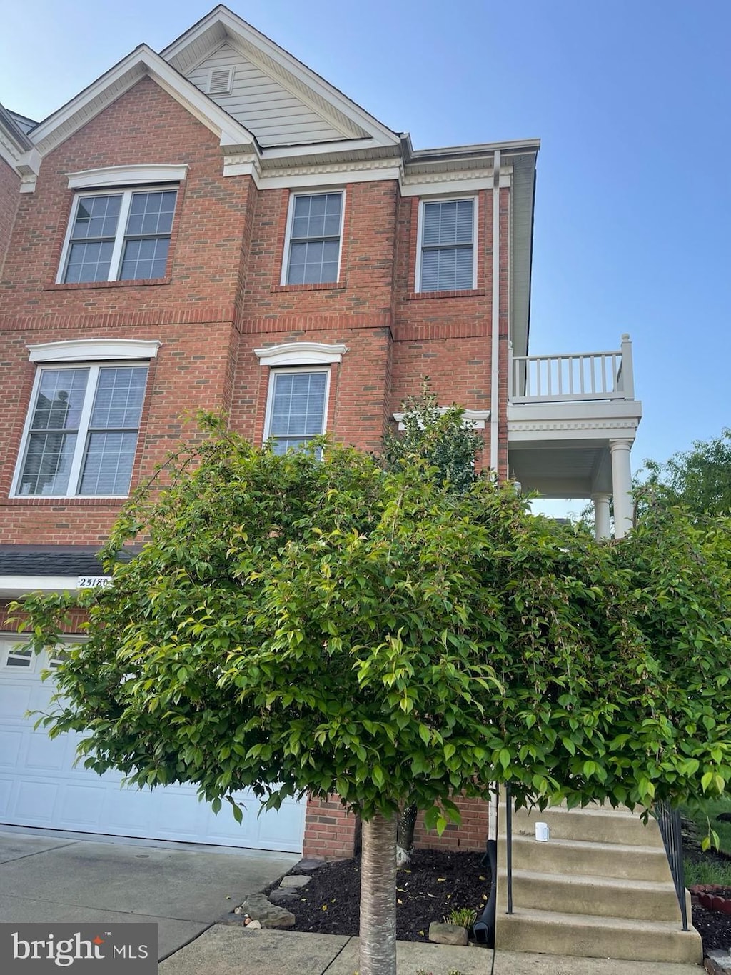 view of front facade with a garage and a balcony