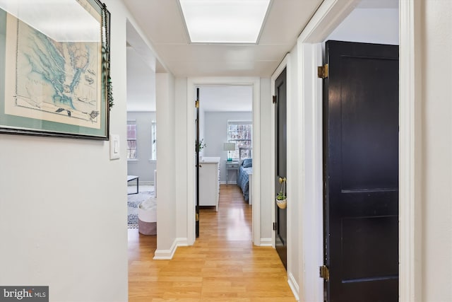 hallway with light hardwood / wood-style floors