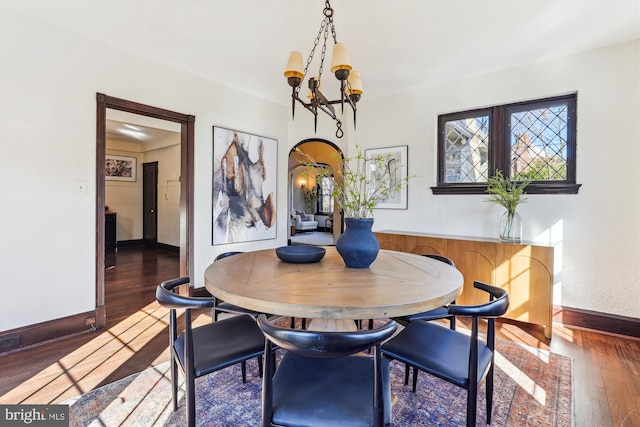 dining area featuring dark hardwood / wood-style flooring and a chandelier