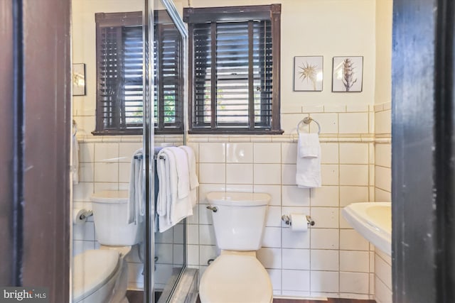 bathroom with tile walls and toilet