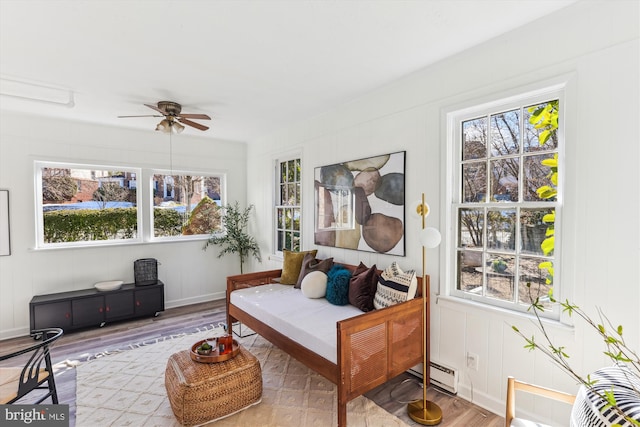 sunroom / solarium featuring baseboard heating and ceiling fan