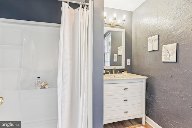 bathroom with wood-type flooring, curtained shower, and vanity