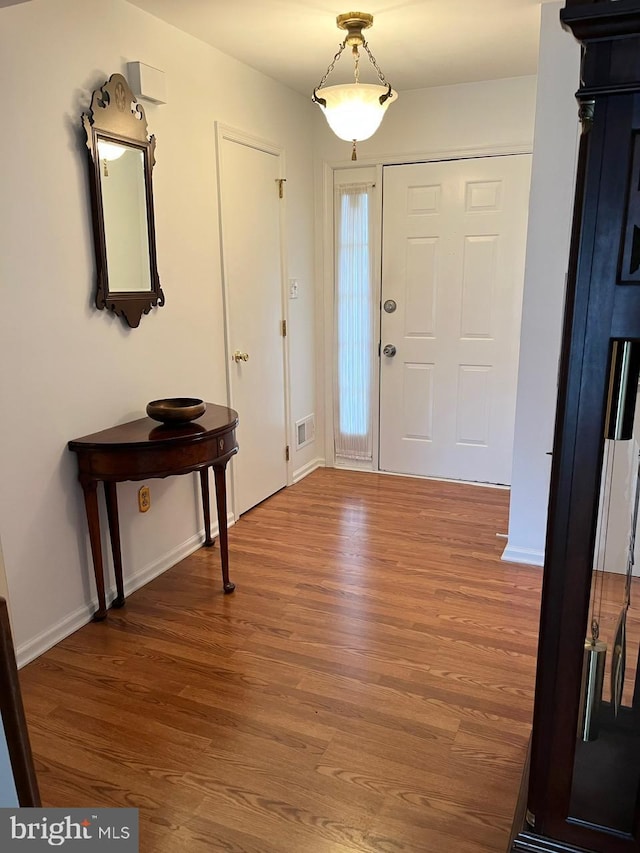 entrance foyer with visible vents, baseboards, and wood finished floors