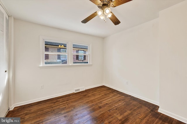 unfurnished bedroom featuring dark wood-type flooring, a closet, baseboards, and ceiling fan