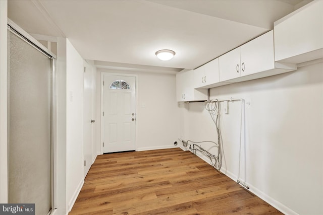 laundry room featuring light wood-style flooring and baseboards