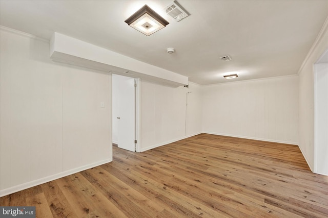 finished below grade area with wood finished floors, crown molding, and baseboards