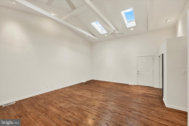 unfurnished room featuring a skylight, beamed ceiling, high vaulted ceiling, ceiling fan, and wood finished floors