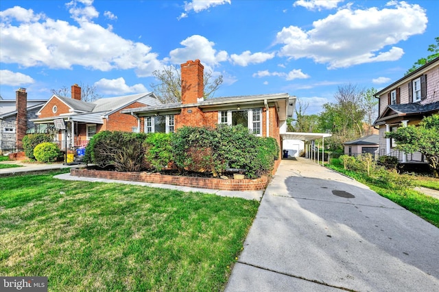 view of front of property with driveway, a carport, brick siding, a front lawn, and a chimney