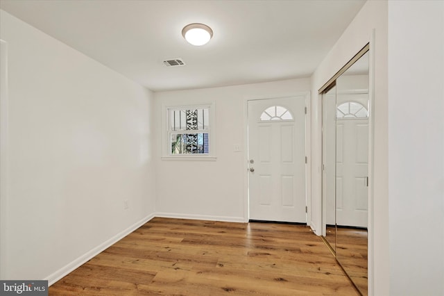 foyer entrance featuring light wood finished floors and baseboards