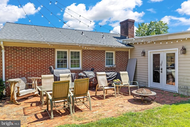 view of patio featuring french doors, a fire pit, and outdoor dining area