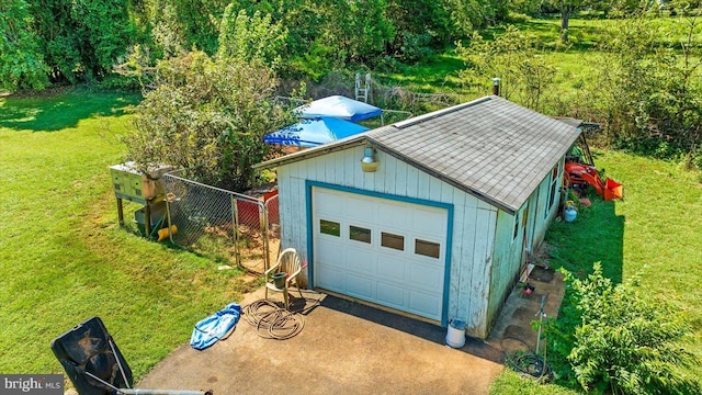 detached garage featuring fence and driveway