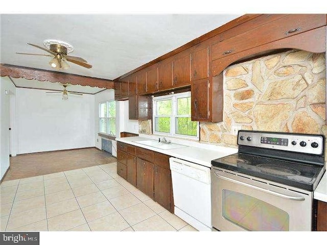 kitchen featuring sink, light tile patterned floors, ceiling fan, white dishwasher, and stainless steel electric range oven