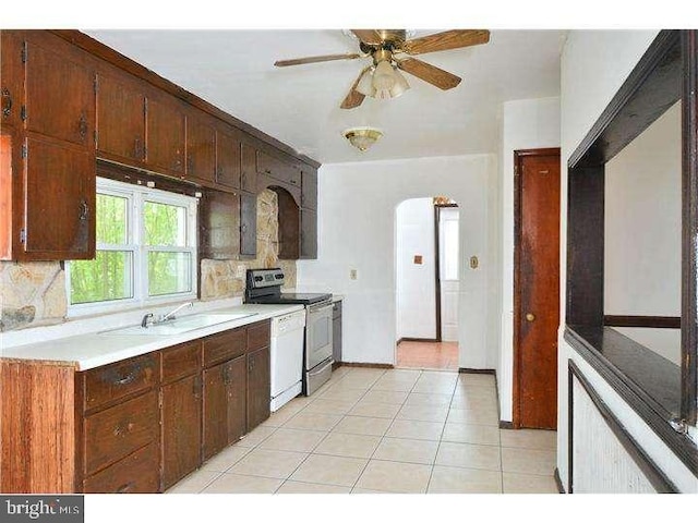 kitchen featuring dishwasher, sink, light tile patterned floors, ceiling fan, and stainless steel electric range