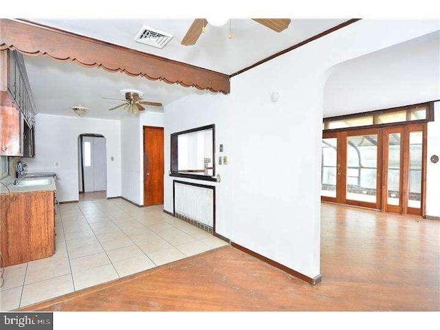 kitchen with sink, light tile patterned floors, and ceiling fan