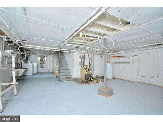 basement featuring washer and clothes dryer and water heater