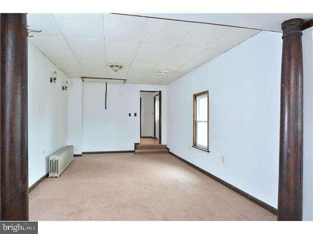 empty room with light carpet and radiator heating unit