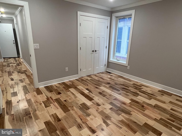 unfurnished bedroom featuring crown molding and light hardwood / wood-style floors