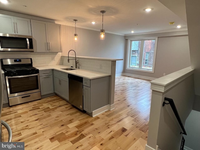 kitchen featuring gray cabinetry, sink, stainless steel appliances, and kitchen peninsula