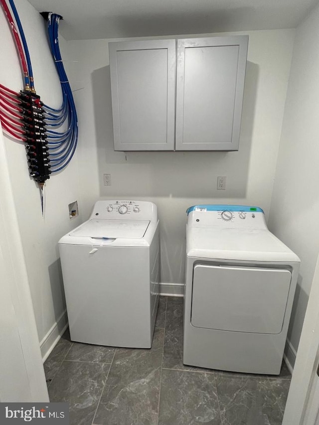 washroom with cabinets and washer and clothes dryer