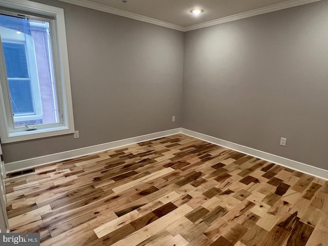 spare room with ornamental molding and light wood-type flooring