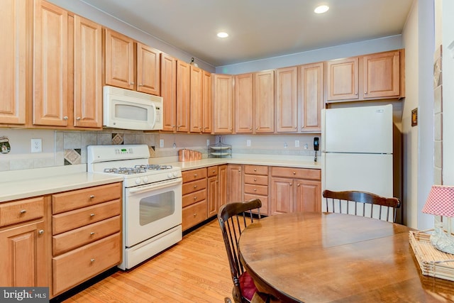 kitchen with light wood-type flooring, light brown cabinetry, and white appliances