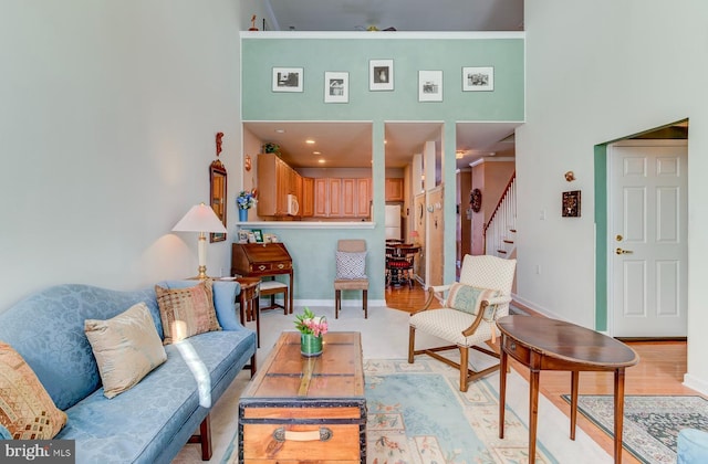 living room featuring a towering ceiling and light hardwood / wood-style flooring