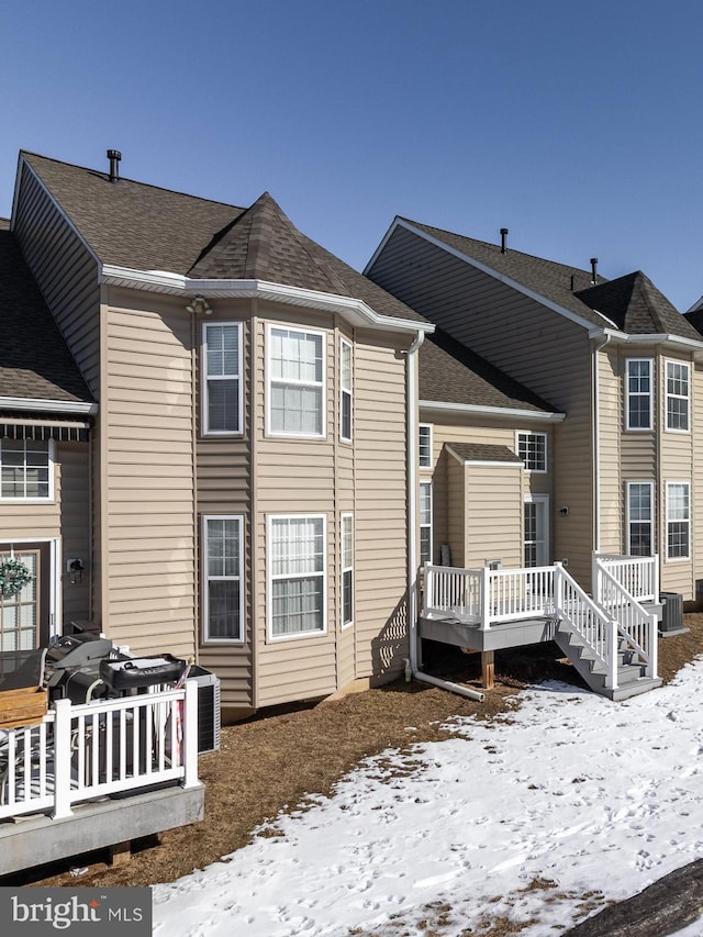 snow covered property featuring a wooden deck and central air condition unit