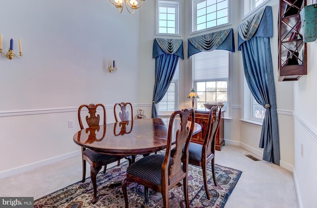 dining area featuring light colored carpet and a notable chandelier