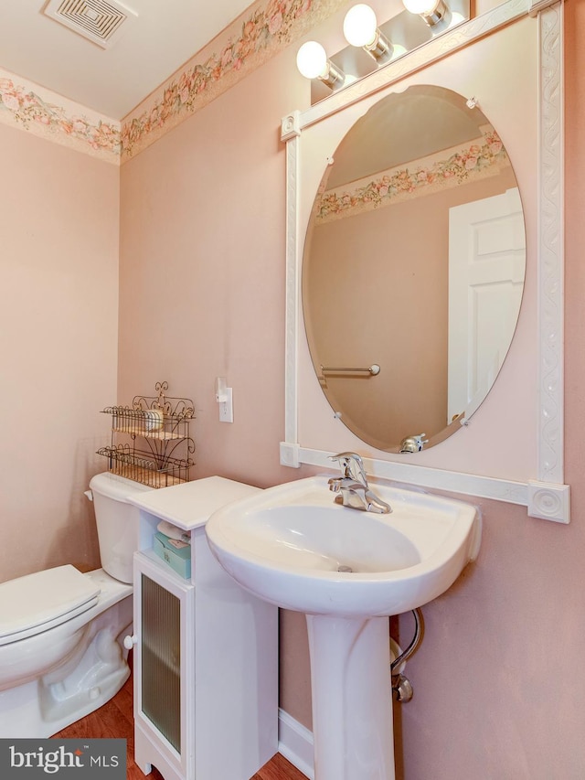 bathroom featuring wood-type flooring and toilet