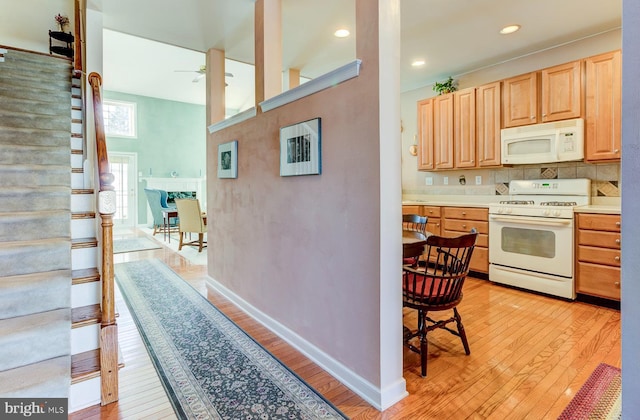 kitchen featuring backsplash, ceiling fan, light brown cabinets, white appliances, and light hardwood / wood-style flooring