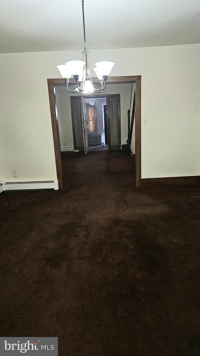 unfurnished dining area featuring an inviting chandelier, a baseboard heating unit, and dark carpet