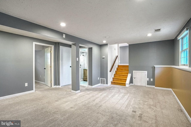 basement with light colored carpet and a textured ceiling