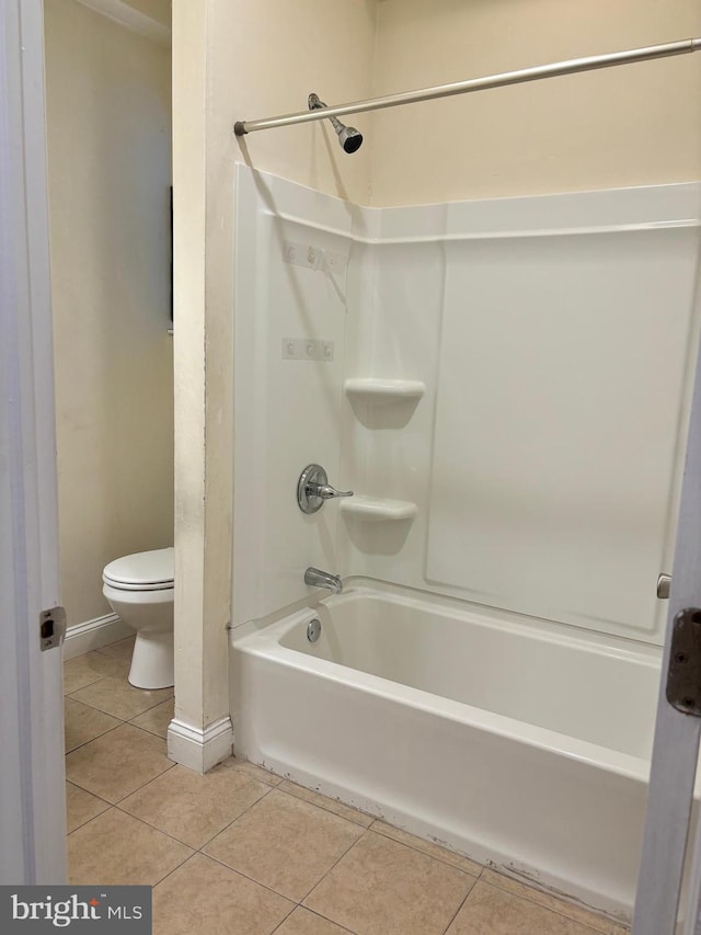 bathroom featuring tile patterned floors, toilet, and bathtub / shower combination