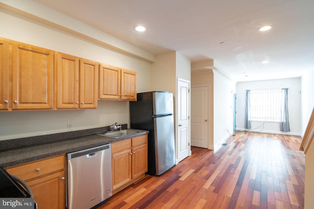 kitchen featuring stainless steel appliances, sink, and dark hardwood / wood-style floors