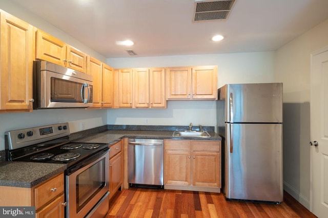 kitchen featuring stainless steel appliances, sink, and hardwood / wood-style floors