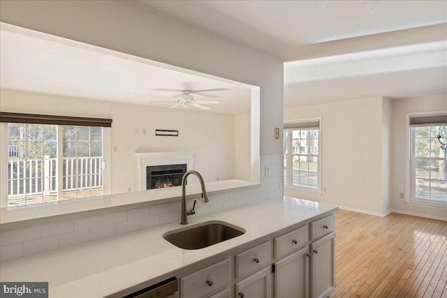 kitchen featuring plenty of natural light, sink, gray cabinetry, and light wood-type flooring