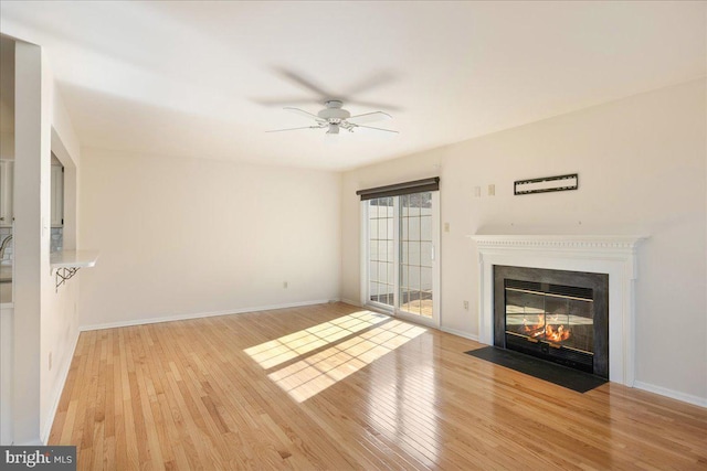 unfurnished living room with light hardwood / wood-style flooring and ceiling fan