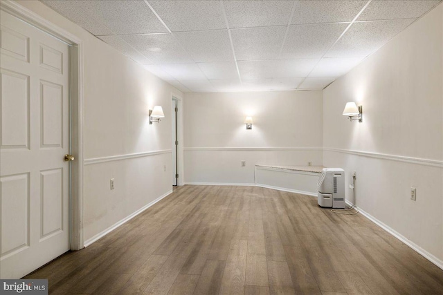 interior space featuring a paneled ceiling and hardwood / wood-style floors