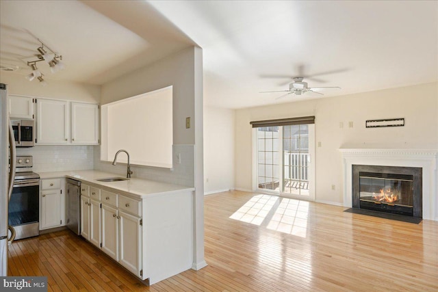 kitchen featuring white cabinetry, appliances with stainless steel finishes, light hardwood / wood-style floors, and sink