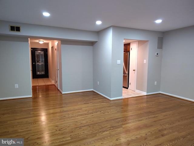 empty room featuring visible vents, recessed lighting, and light wood-style floors