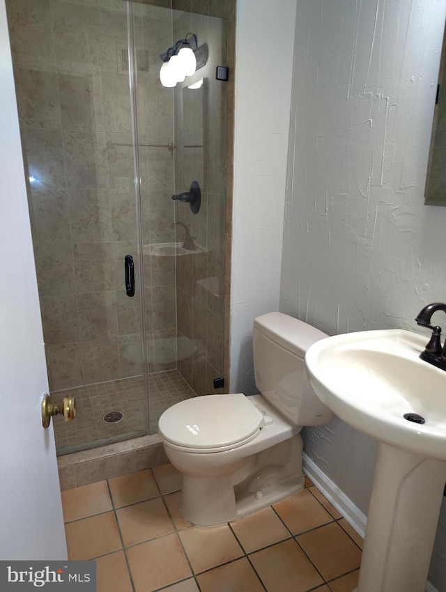 full bath with baseboards, toilet, a stall shower, and tile patterned flooring