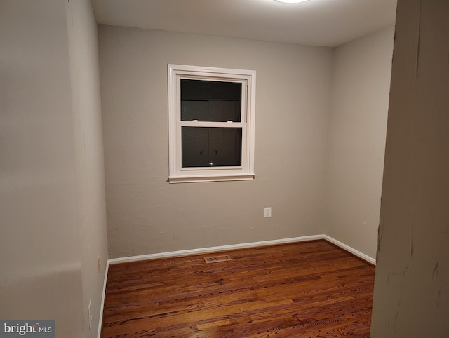 spare room featuring visible vents, wood finished floors, and baseboards